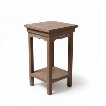 Hand-carved floral apron detail on a Balinese teak side table — white background