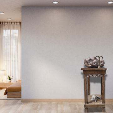 Wooden side table with decorative items against a plain wall in a room.
