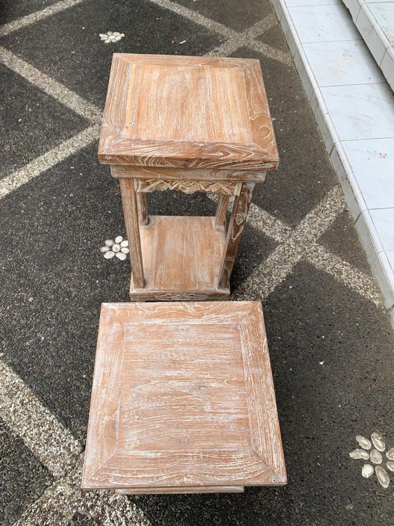 Two wooden tables on a stone pavement