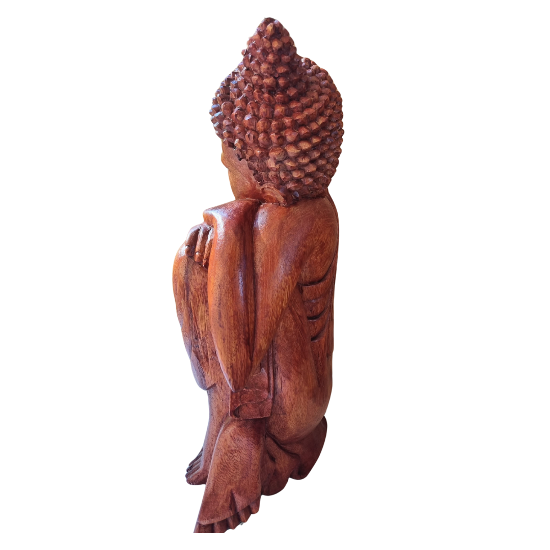 Hand-carved wooden Buddha statue, side profile view showing robe detail and timber grain, white background