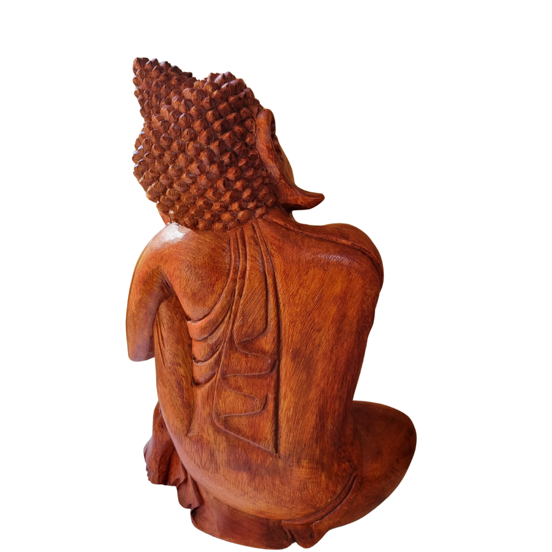 Hand-carved wooden Buddha statue, side-rear view showing robe drape and timber grain detail