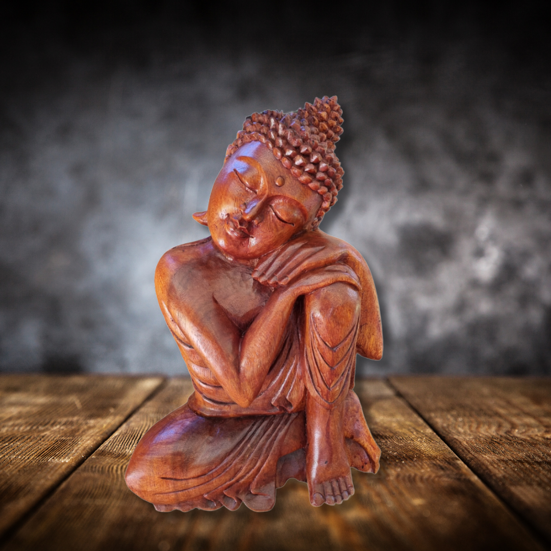 Buddha statue on a wooden surface with a dark background