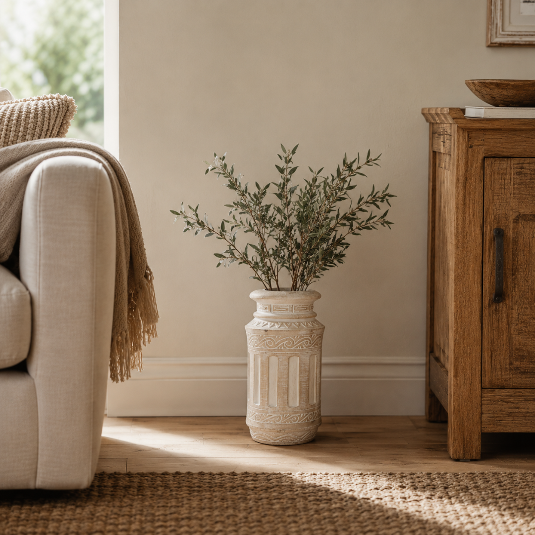 Roman column carved Living room with beige sofa, wooden cabinet, and decorative vase with greenery.