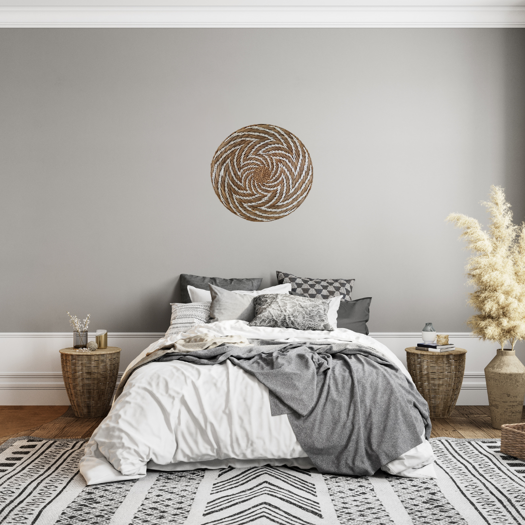 Large handwoven seagrass spiral wall art leaning on timber surface – brown natural fibre with white rope spiral detail, ready to hang Australia