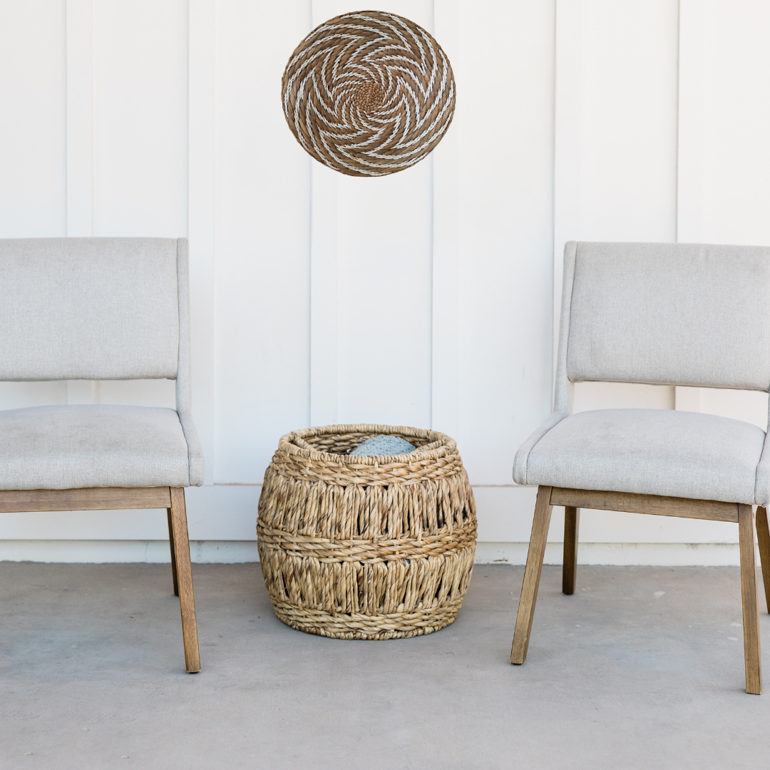 Seagrass spiral wall art on white shiplap wall styled with linen chairs and woven basket – coastal boho décor