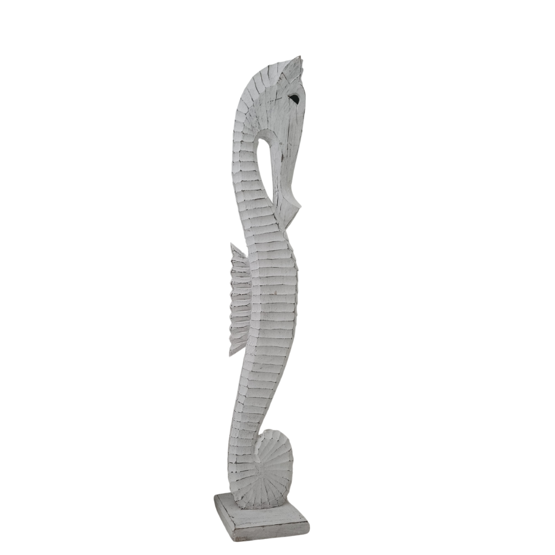 large wooden seahorse wooden statue on a white back wall 
