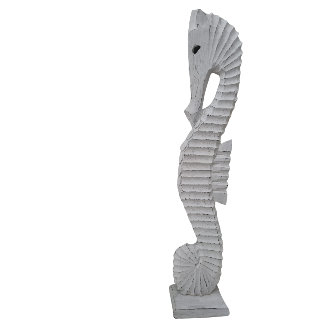 side view of a white wooden seahorse statue on a white back wall