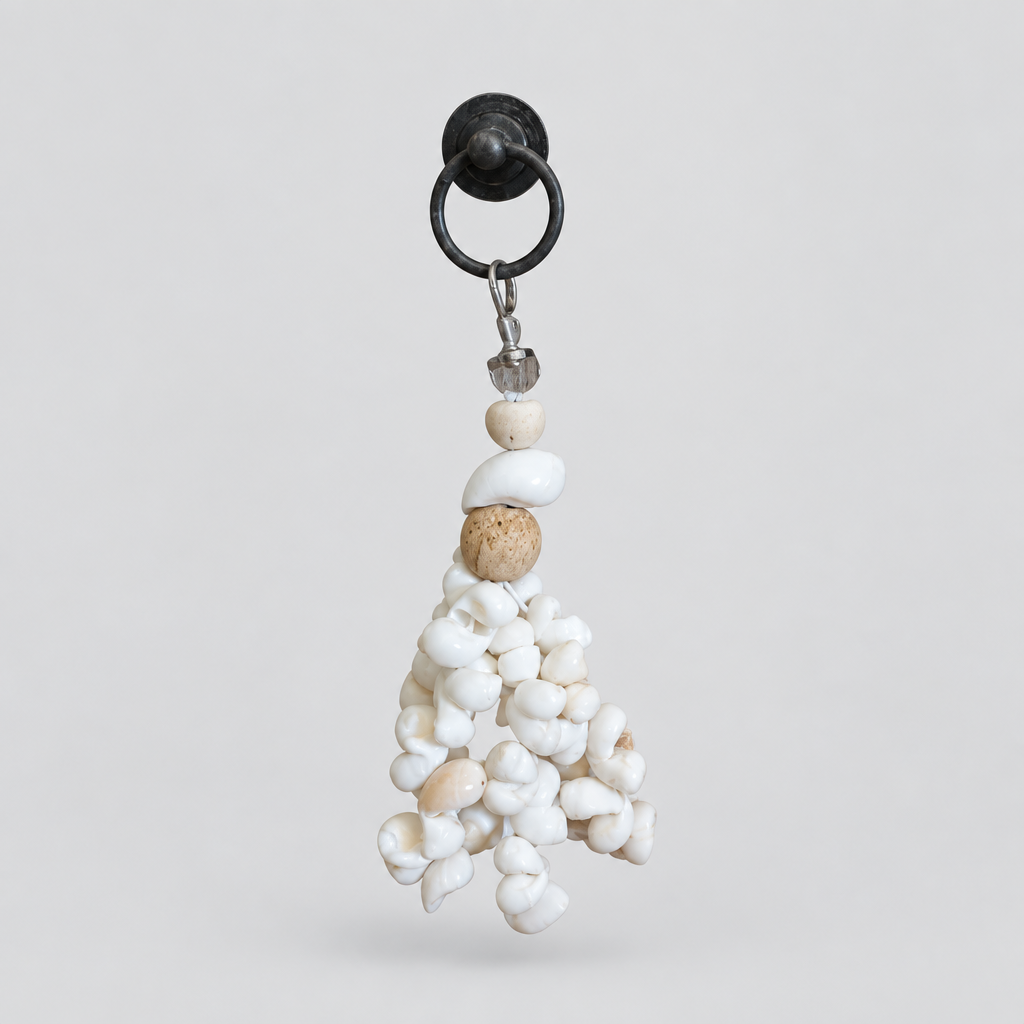 Seashell Serenity Tassel Decor hanging from a black hook, showing white shells, wooden beads and silver clip