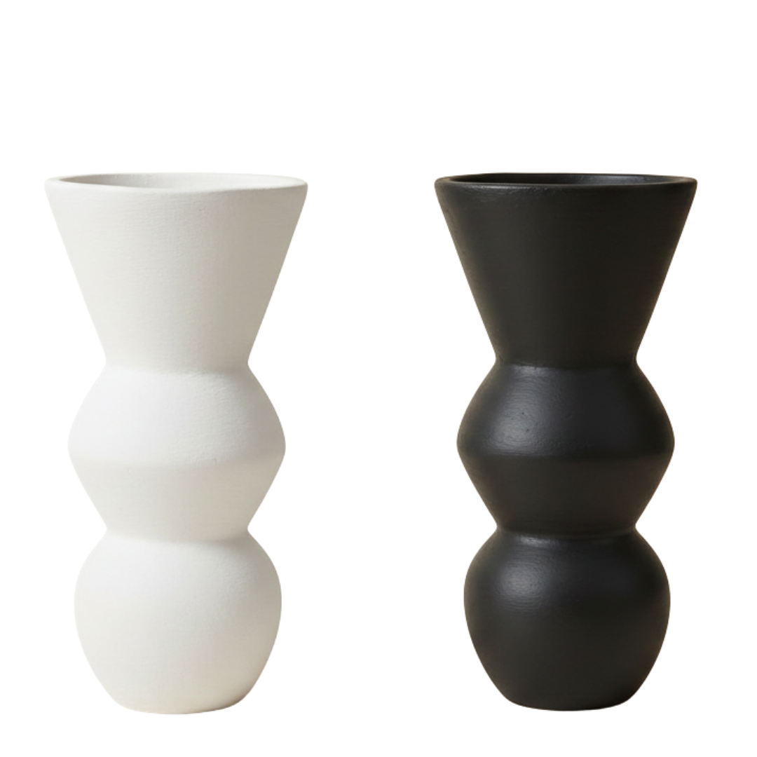 Two sculptural decorative objects side by side on a white background — one matte white, one matte black, showing both colour options