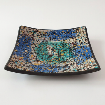 angled view on white: Splash Mosaic Bowl Decor with blue, turquoise and cream tiles, curved corners and a black rim.