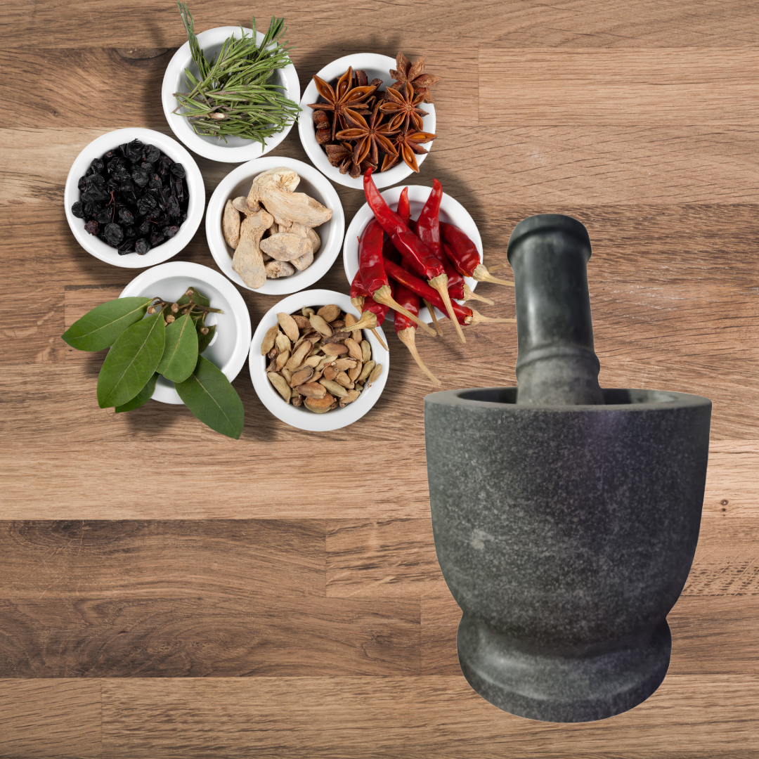 Stone mortar and pestle set styled with ground turmeric, chilli powder, and fresh herbs – ideal for grinding spices and curry pastes