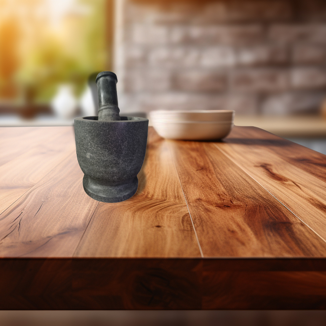 Natural stone mortar and pestle set on a timber kitchen bench, showing textured volcanic stone finish and sturdy base