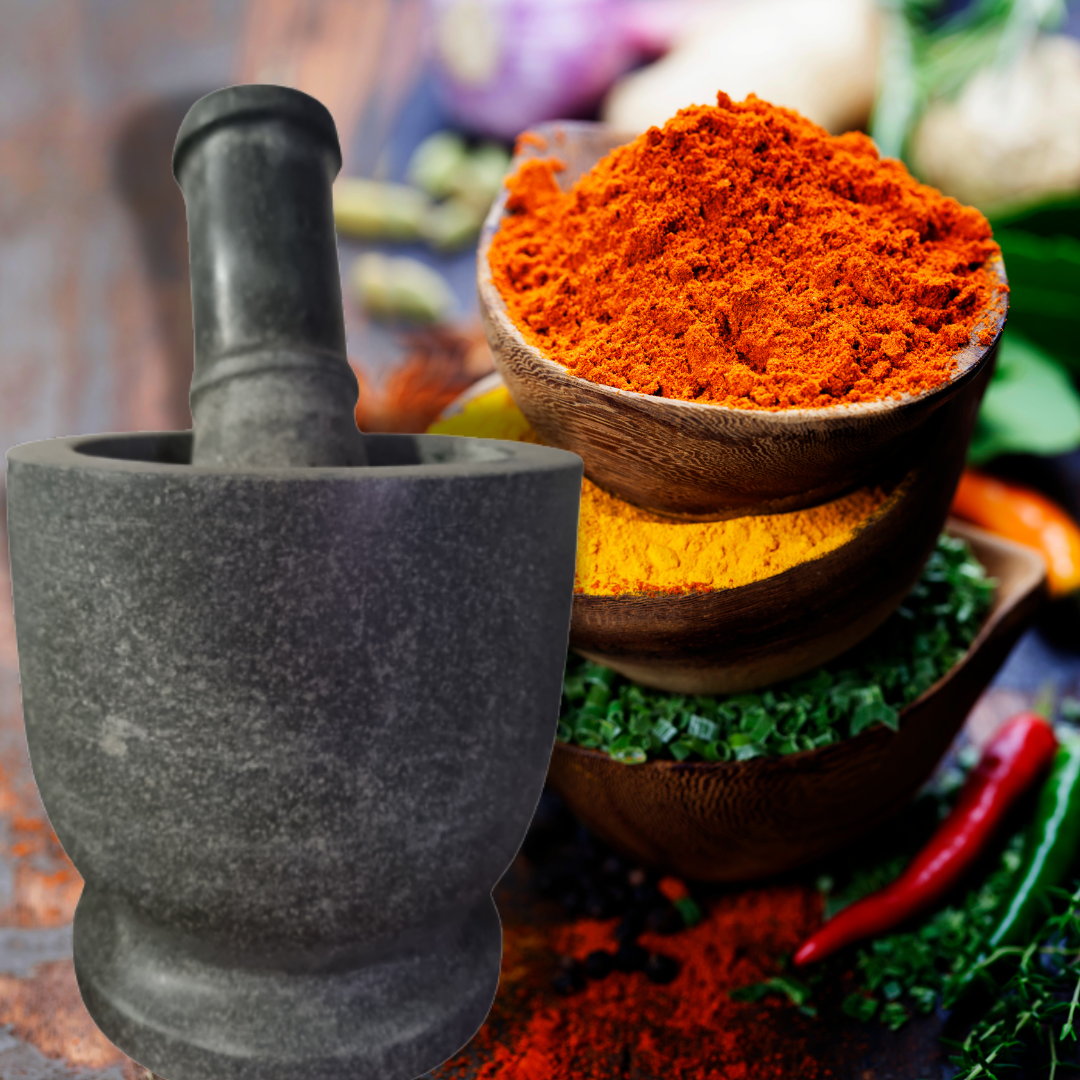 Stone mortar and pestle set styled with ground turmeric, chilli powder, and fresh herbs – ideal for grinding spices and curry pastes