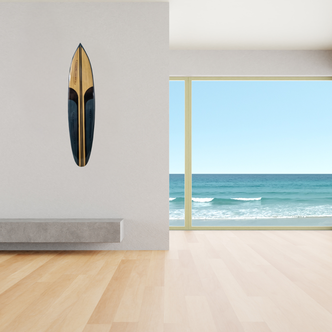 Wooden surfboard on a wall with a view of the ocean through a window.