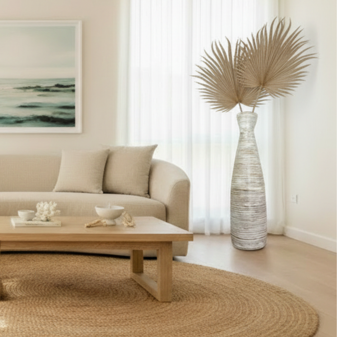 Living room with beige sofa, wooden coffee table, and decorative vase with dried plants.
