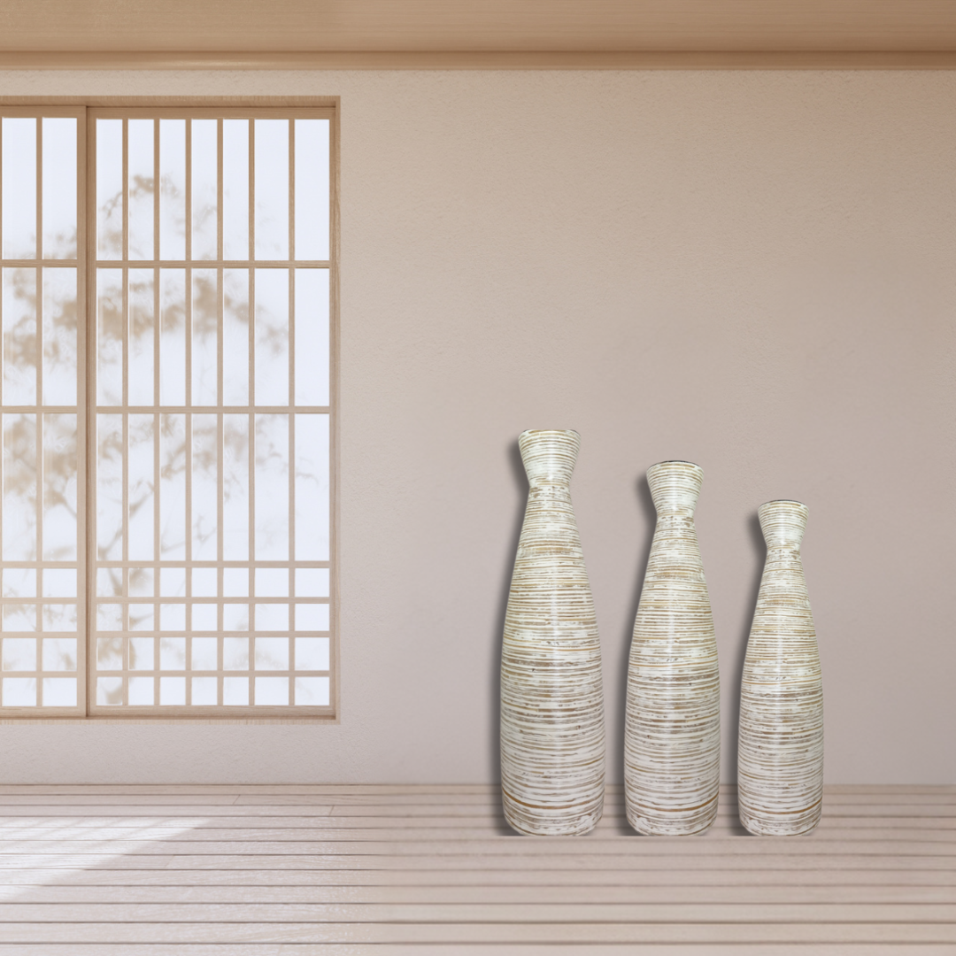 Three textured vases on a wooden floor with a light-colored wall and window in the background