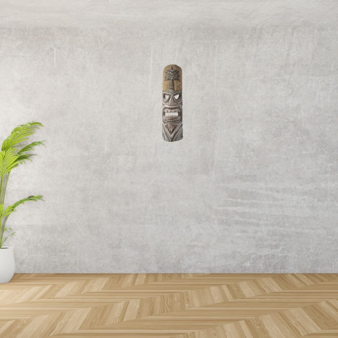 Tiki mask on a textured wall with a plant and wooden floor.