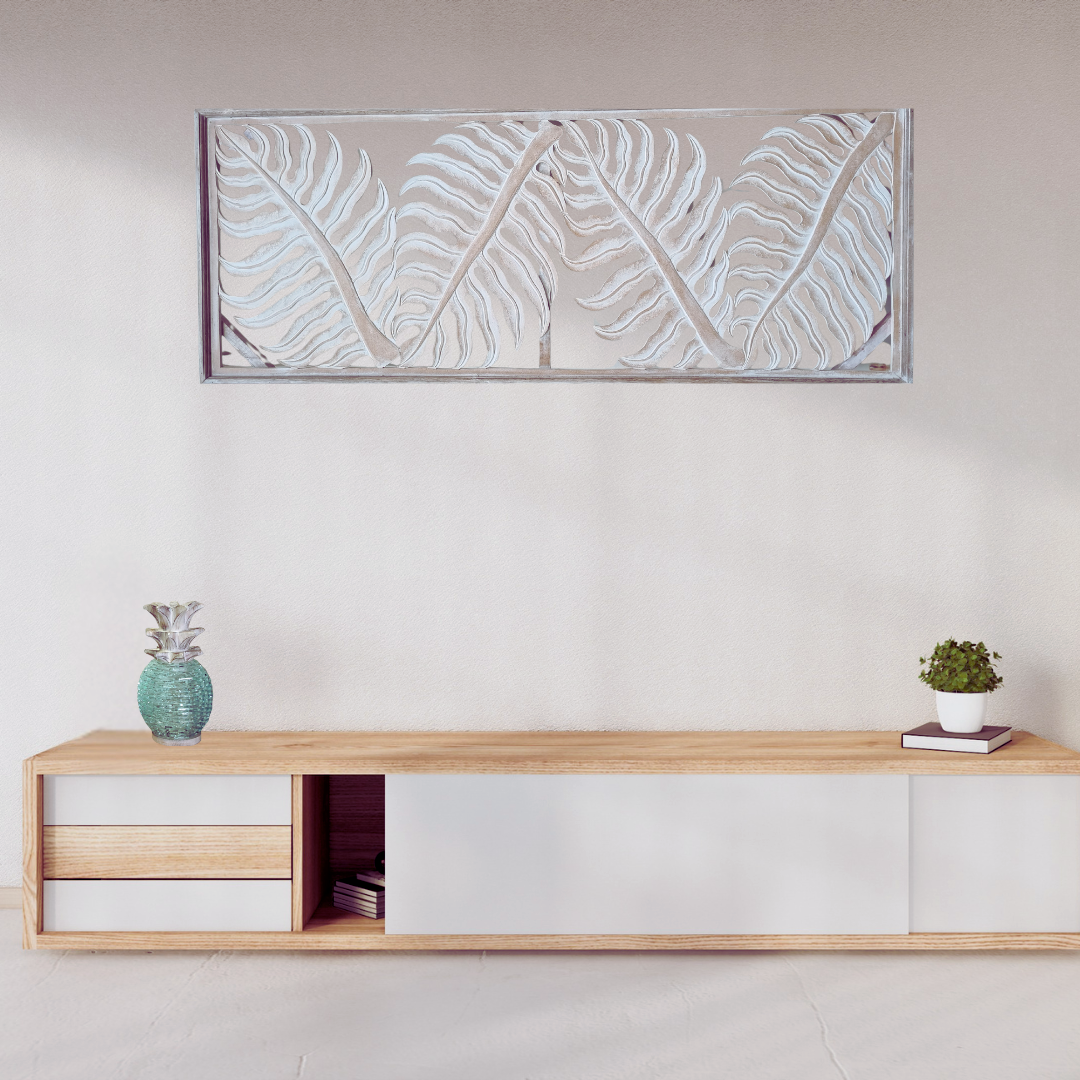 Tropical fern leaf wall hanging in natural wash  wash finish displayed horizontally above a timber console table with pineapple sculpture