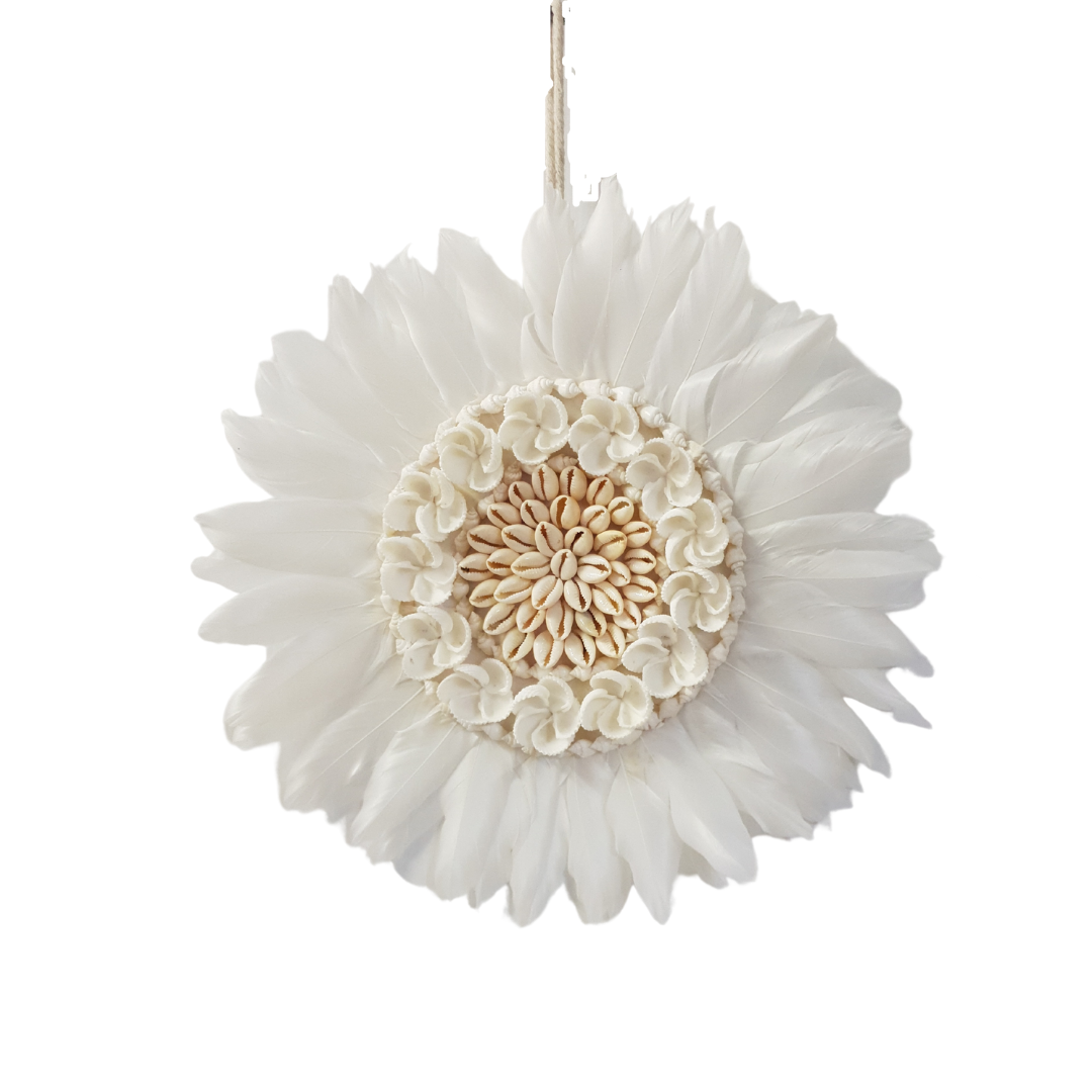 Round white feather wall hanging with a cream cowrie shell rosette centre and a ring of small carved shell flowers, on a white background
