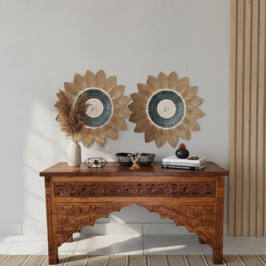 wall art pieces hung above an ornate carved timber console table styled with decorative bowls and dried botanicals in a coastal boho hallway