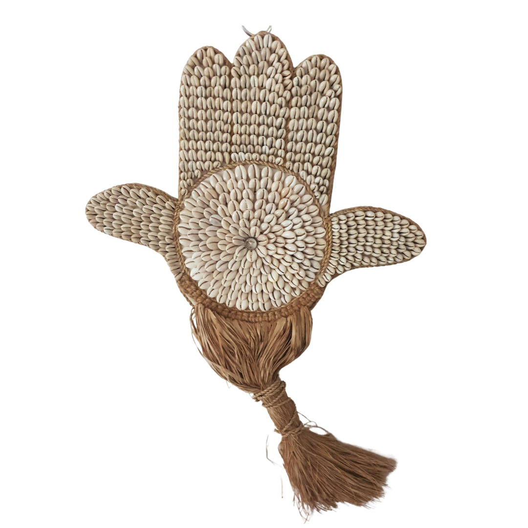 Handmade woven object resembling a hand with a tassel on a white background