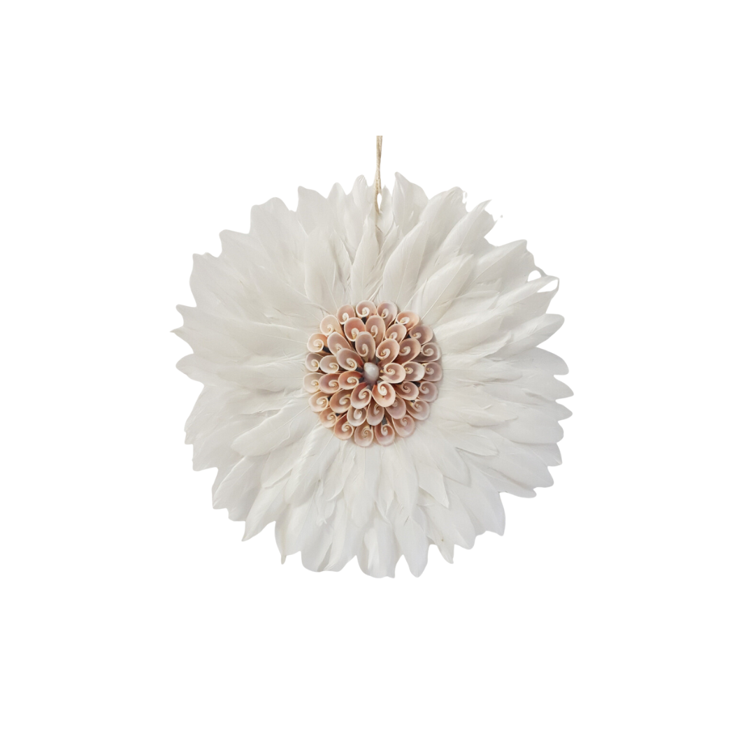 Close-up of a round white feather wall hanging with layered white feathers and a blush pink spiral shell centrepiece on a white background, hanging string visible at top