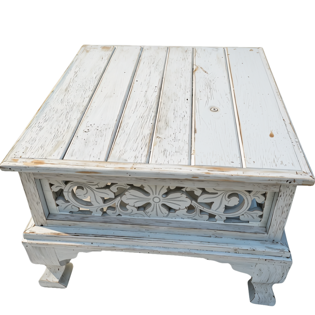distressed white wooden table with ornate scrollwork styled in a bright coastal living room beside a cream sofa and potted plant