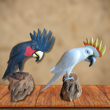 Two cockatoo figurines on wooden stands against a beige background