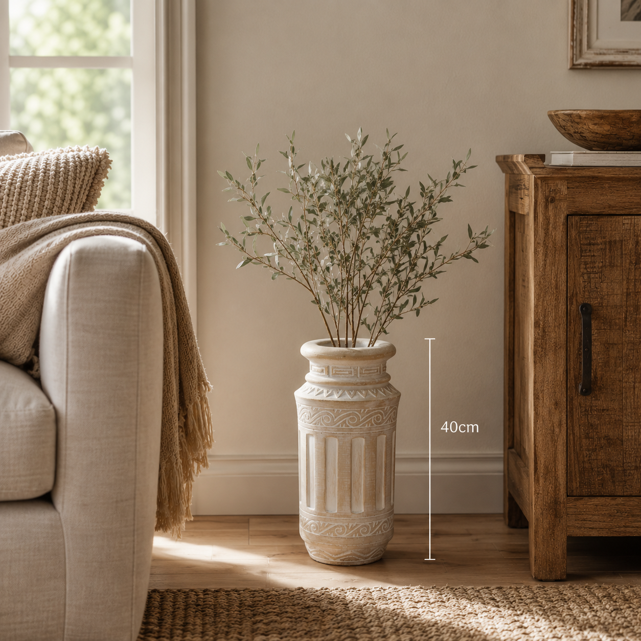 Decorative plant in a tall vase next to a sofa and wooden cabinet in a living room.