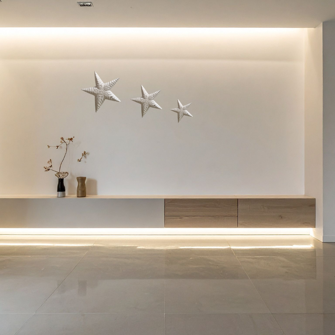 Modern interior with a light wood console table against a white wall with starfish decorations.