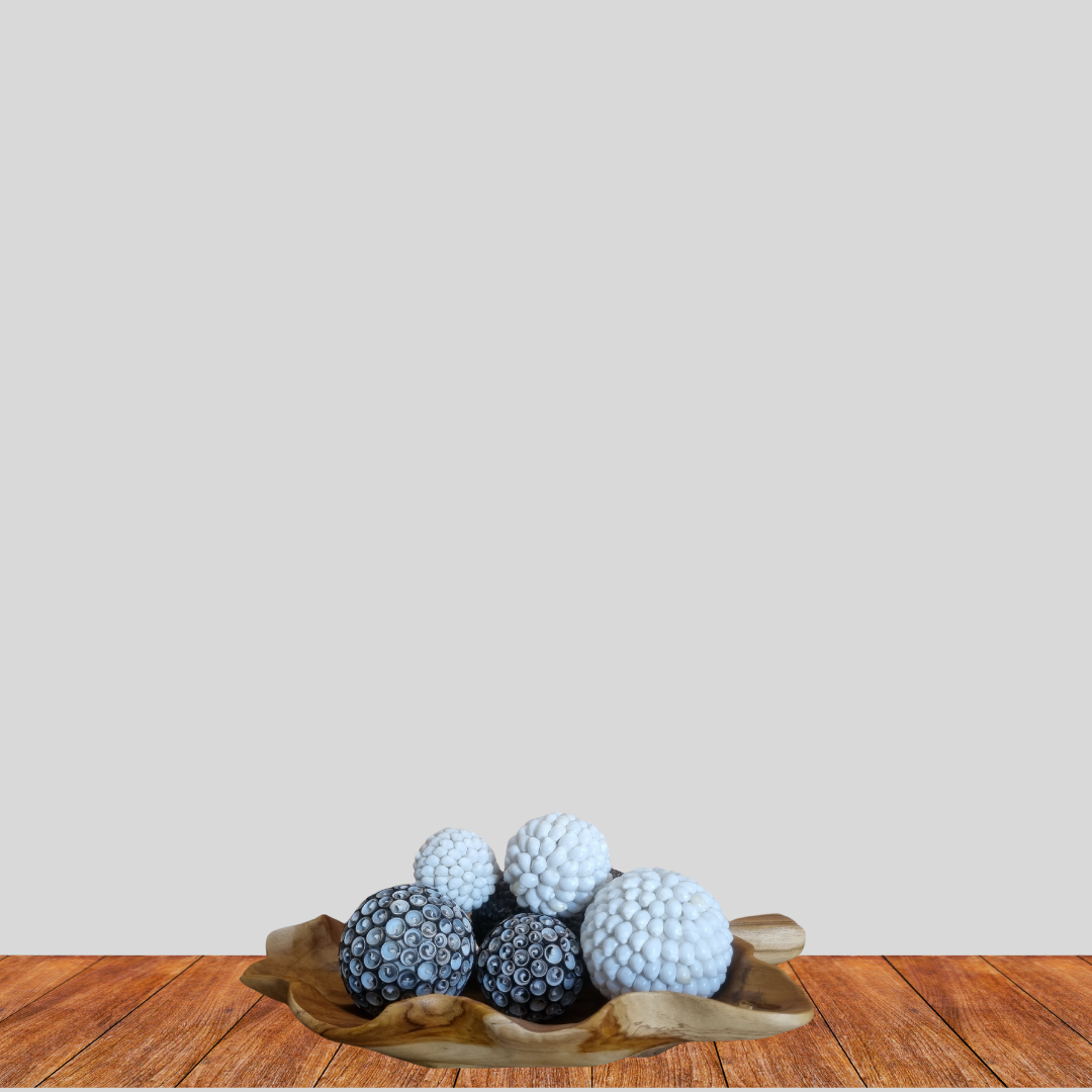 Decorative items with spherical designs on a wooden surface against a plain background