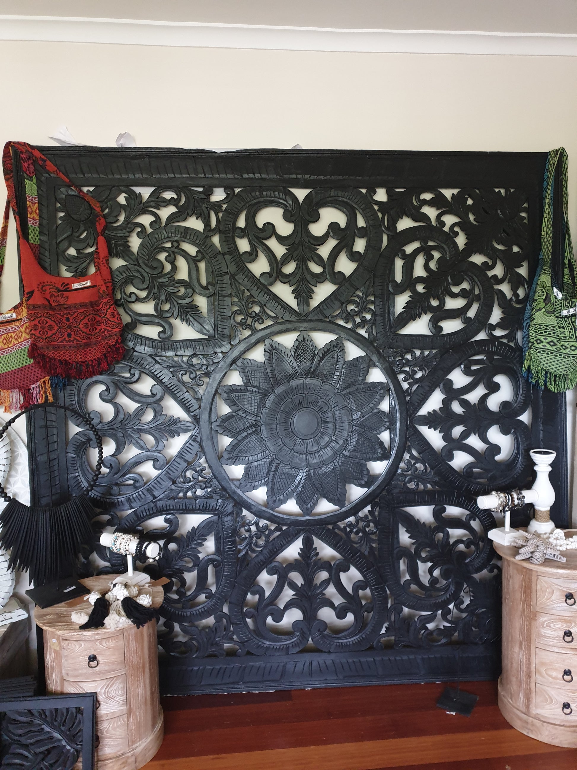 Decorative black metal gate with intricate designs on a white wall.