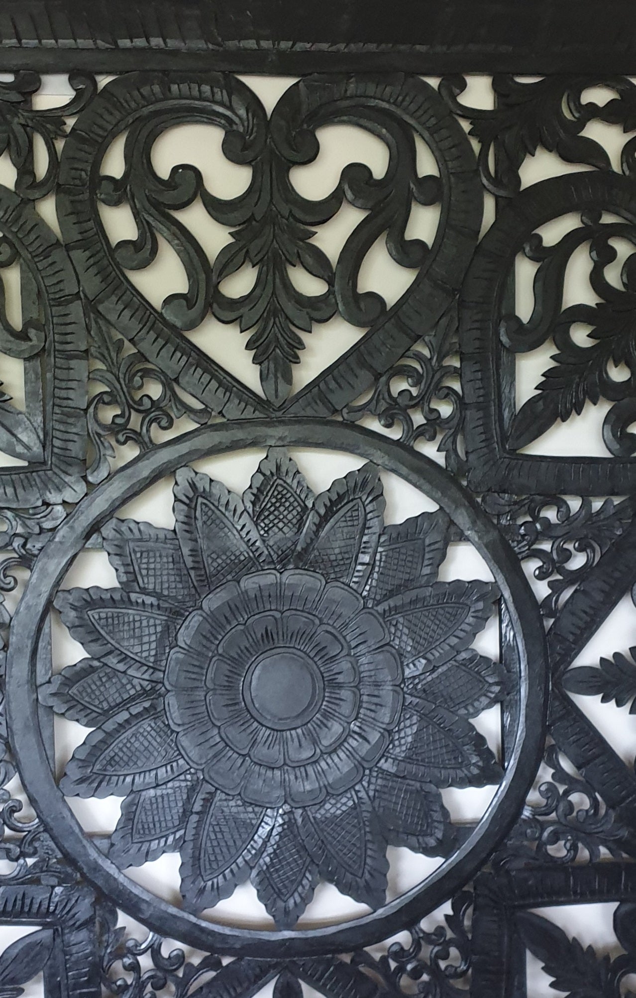 Decorative metal panel with intricate black floral design on a white background