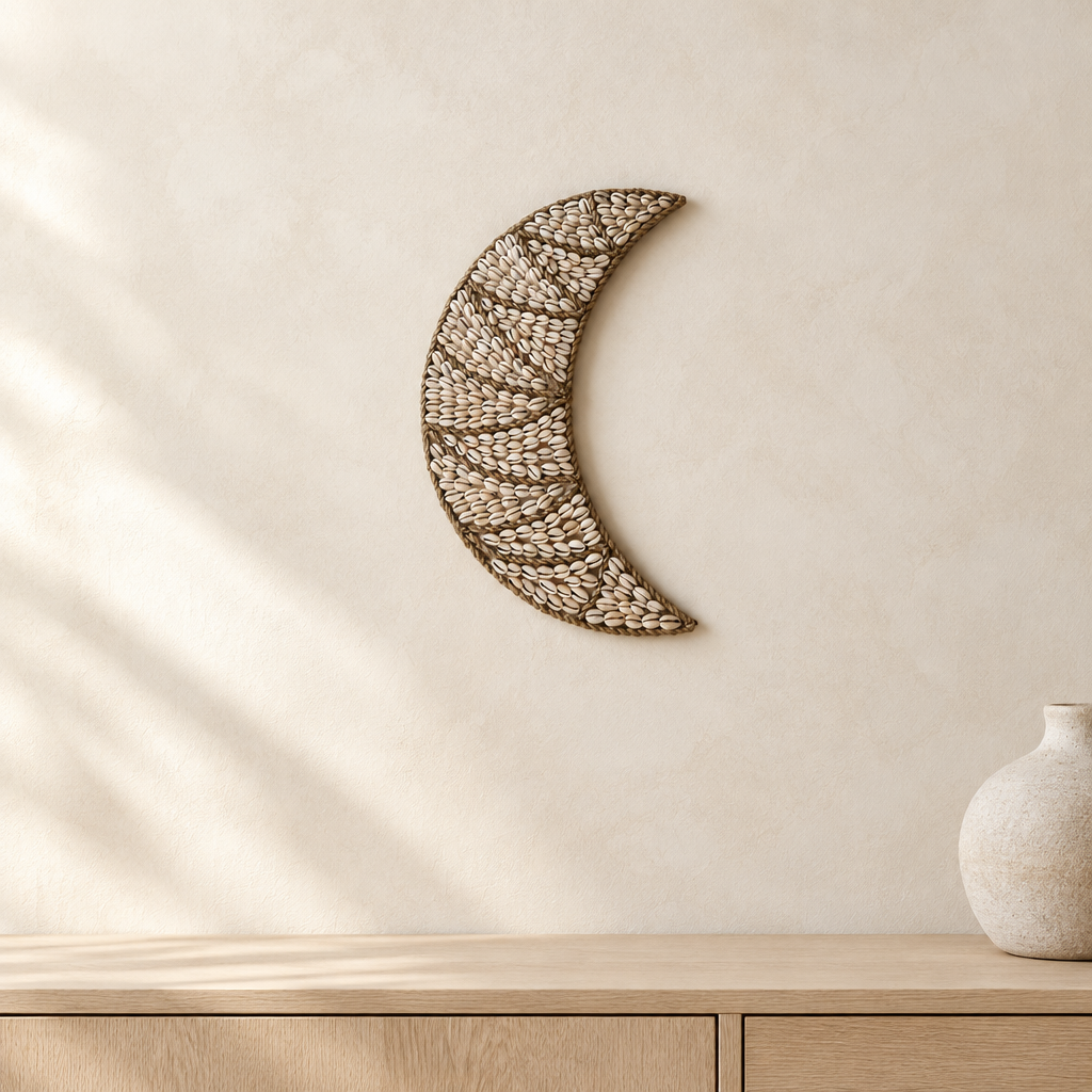 Crescent wall hanging on a neutral-toned wall above a cabinet and ceramic pot