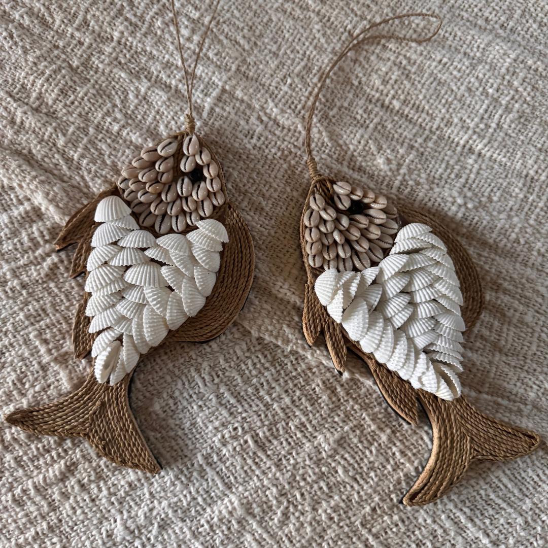 Two fish-shaped decorations made of braided rope on a textured fabric background