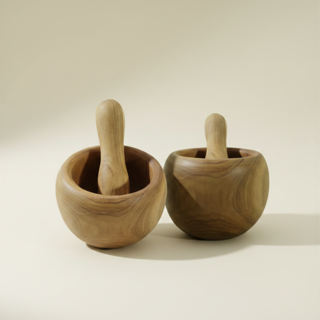 Two round teak wood mortar and pestle sets side by side on a warm cream background, showing contrasting light and dark natural wood tones