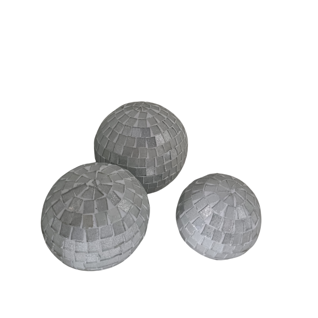 Three white mosaic glass spheres in large, medium and small sizes grouped together on a white background