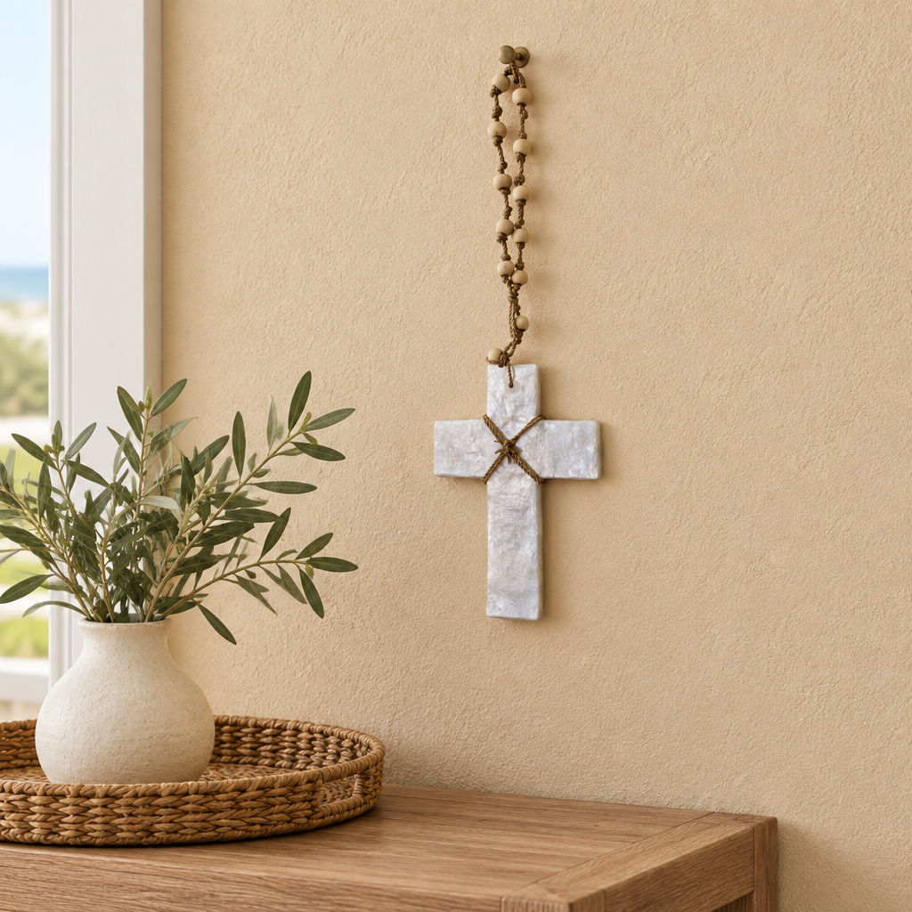 capiz cross set above a console table with a warm natural try with a terricotta vase with olive tree leaves 