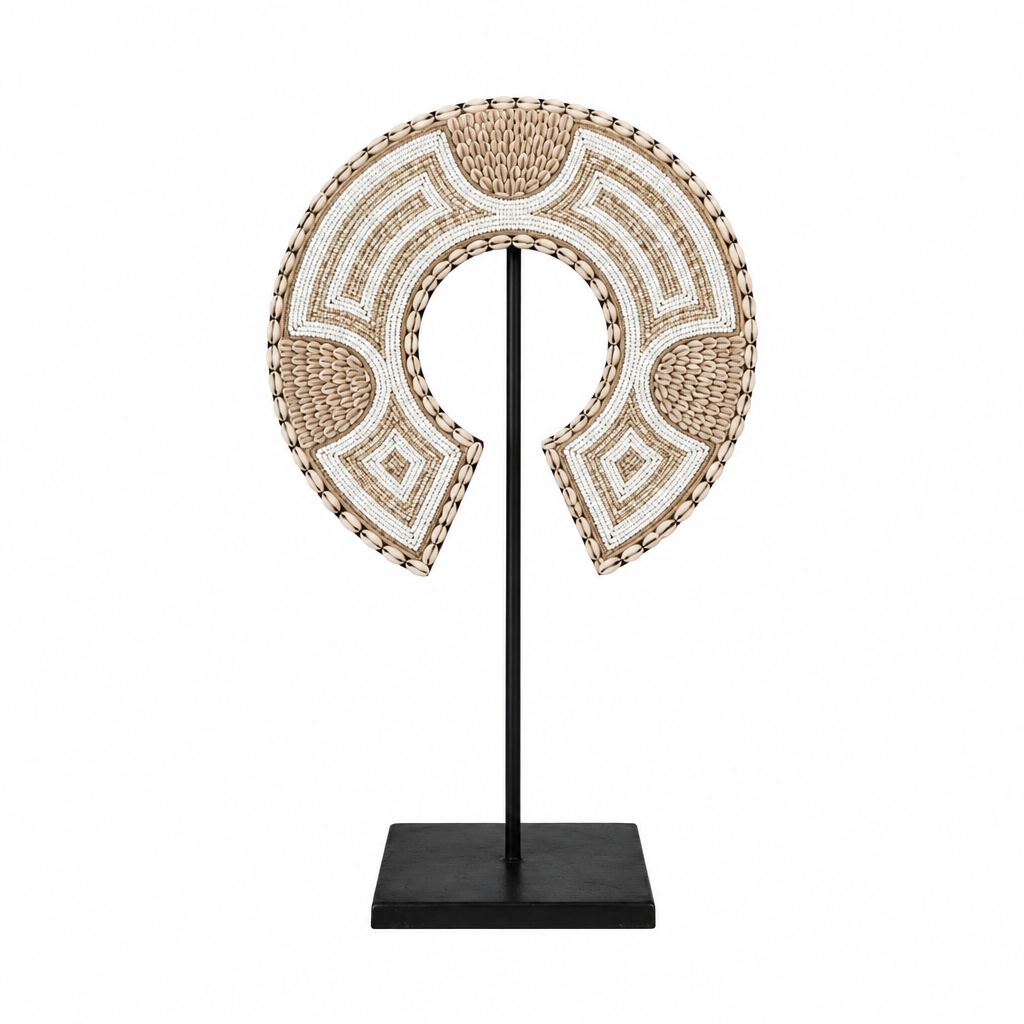 Small crescent-shaped decoration with beige and white beadwork on a black metal stand against a white background