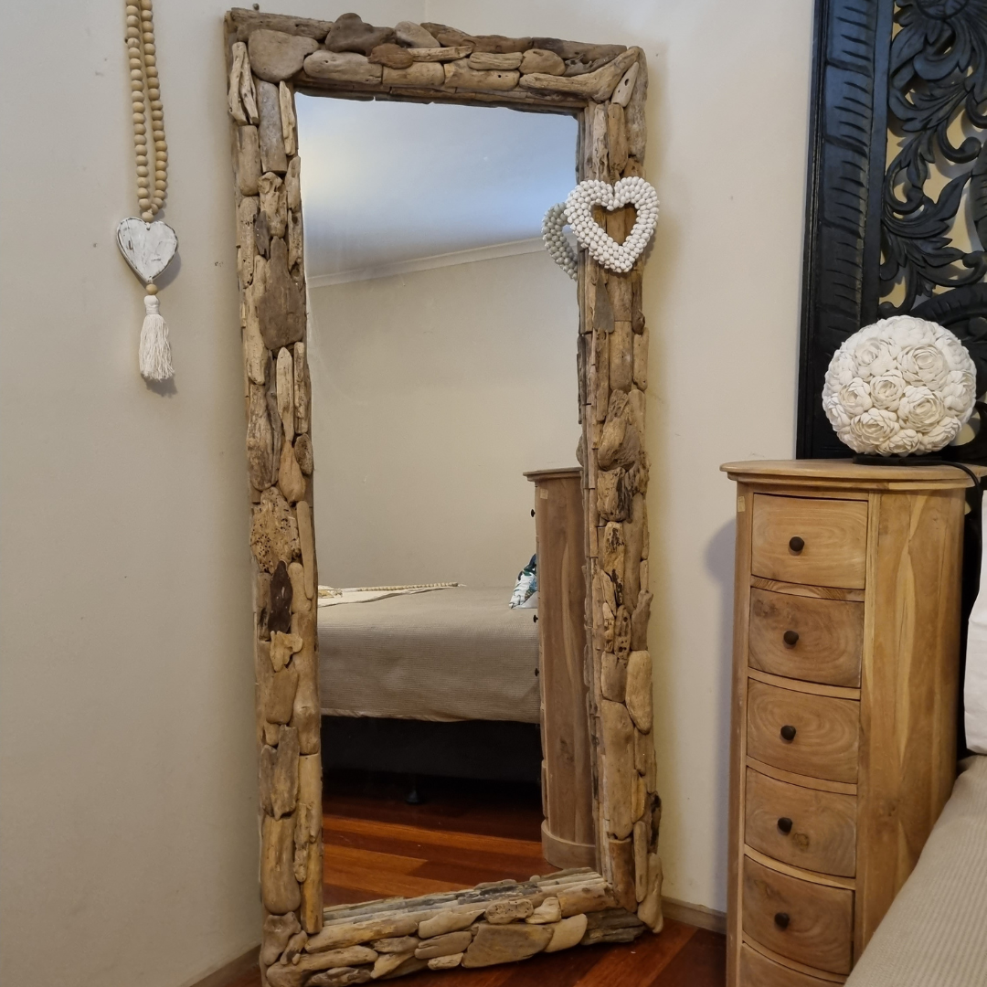 Large rectangular driftwood wall mirror leaning vertically in a coastal boho bedroom beside a timber dresser — chunky mosaic natural driftwood frame, 80x180cm — handcrafted wall mirror by Azure Decor
