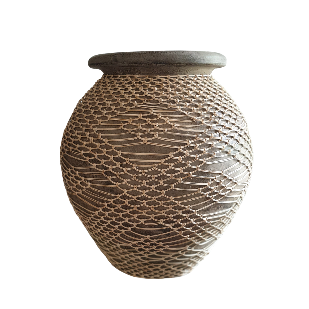 Globe-shaped warm vase with knotted natural rope net wrap on a white background